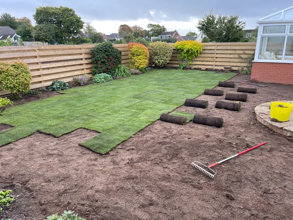 Fresh turf partially laid with rolls ready for the remaining ground