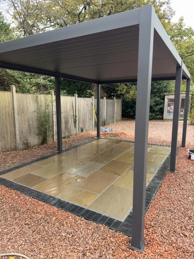 Finished charcoal pergola over natural stone patio